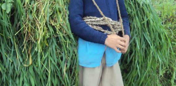 Our culture boy carring grass on his shoulders